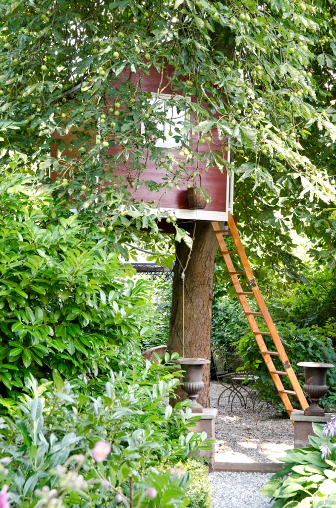 Garten im Sommer und Bilder vom selbst gebauten Baumhaus im Look eines schwedischen Holzhauses