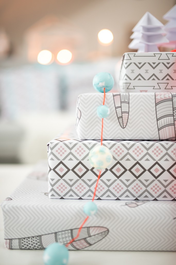 Dekoideen in grau und Pastellfarben für das Wohnzimmer an Weihnachten mit Geschenkpapier im Ethno Look