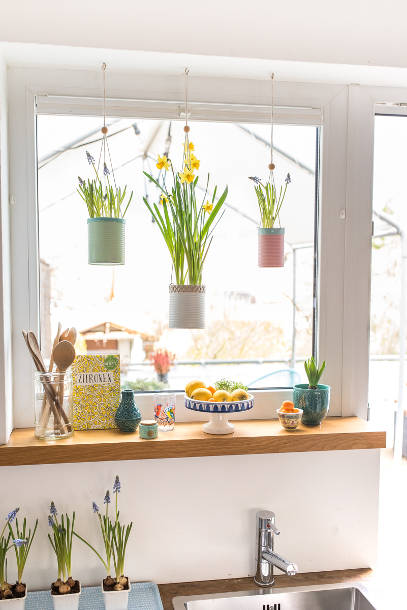 Selbst gemachte upcycling DIY Blumenampeln aus alten Dosen in Pastellfarben als Deko für das Küchen Fenster im Frühling