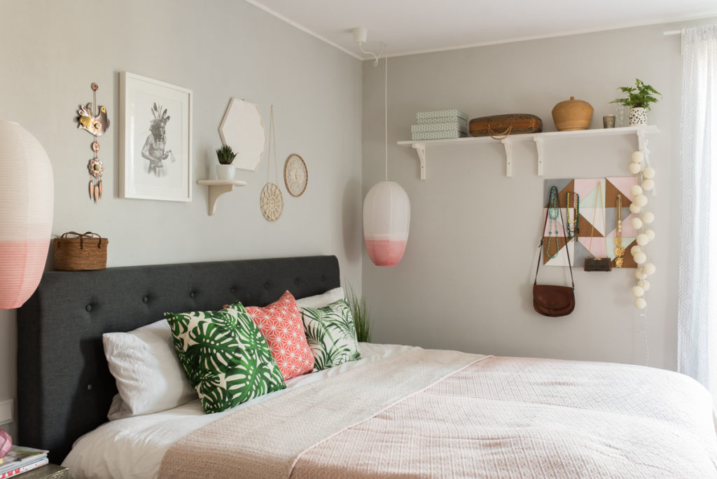 Dekoideen für das Schlafzimmer im skandinavischen vintage Look mit grauem Boxspringbett, grauen Wänden und Deko in der Farbe Koralle und Mint