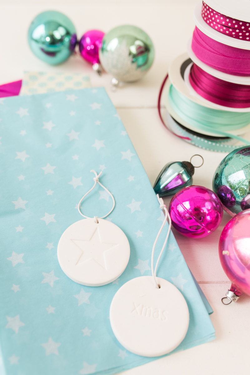 Anleitung für einen selbst gemachten DIY Adventskalender an einem Ast mit Spitztüten aus schwarzem Tafelstoff und Deko in Pink und Türkis als Weihnachtsdeko im Advent