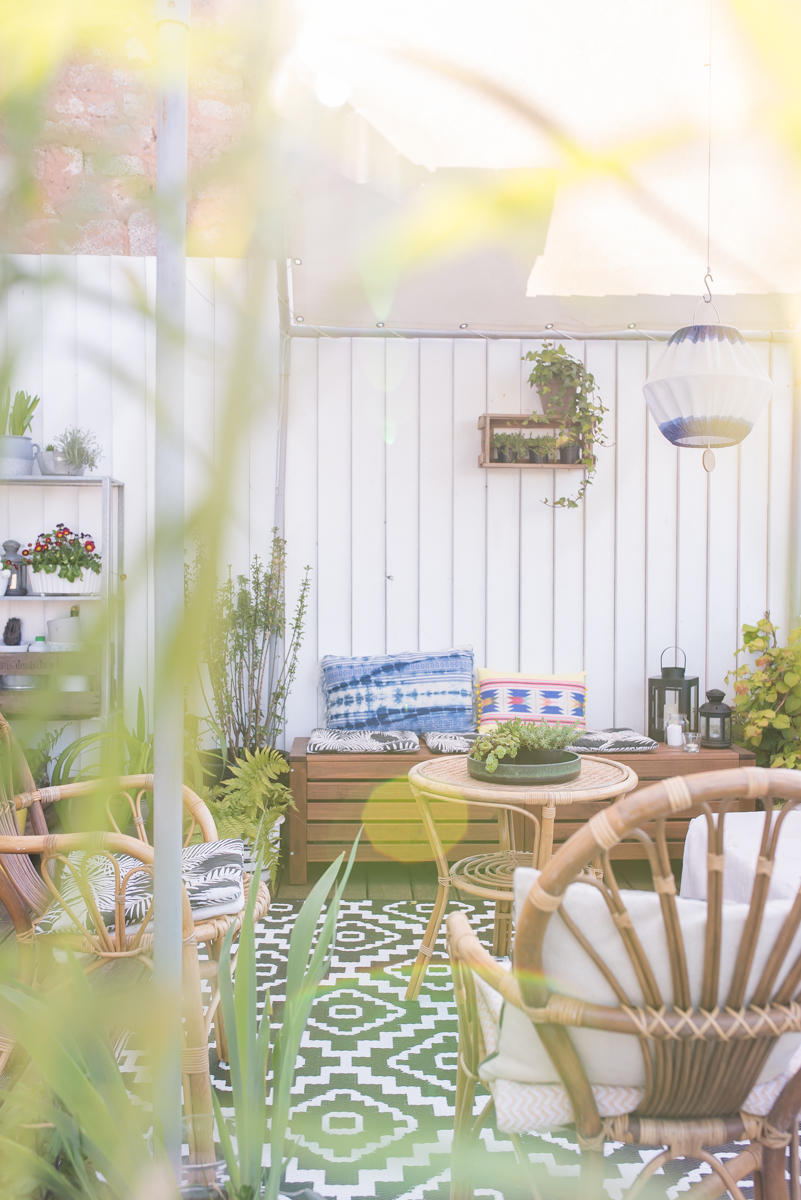 So richtet ihr euch ein outdoor Wohnzimmer auf dem Balkon im Boho Look ein und dekoriert mit bunten Kissen, Teppichen und Pflanzen in Kübeln
