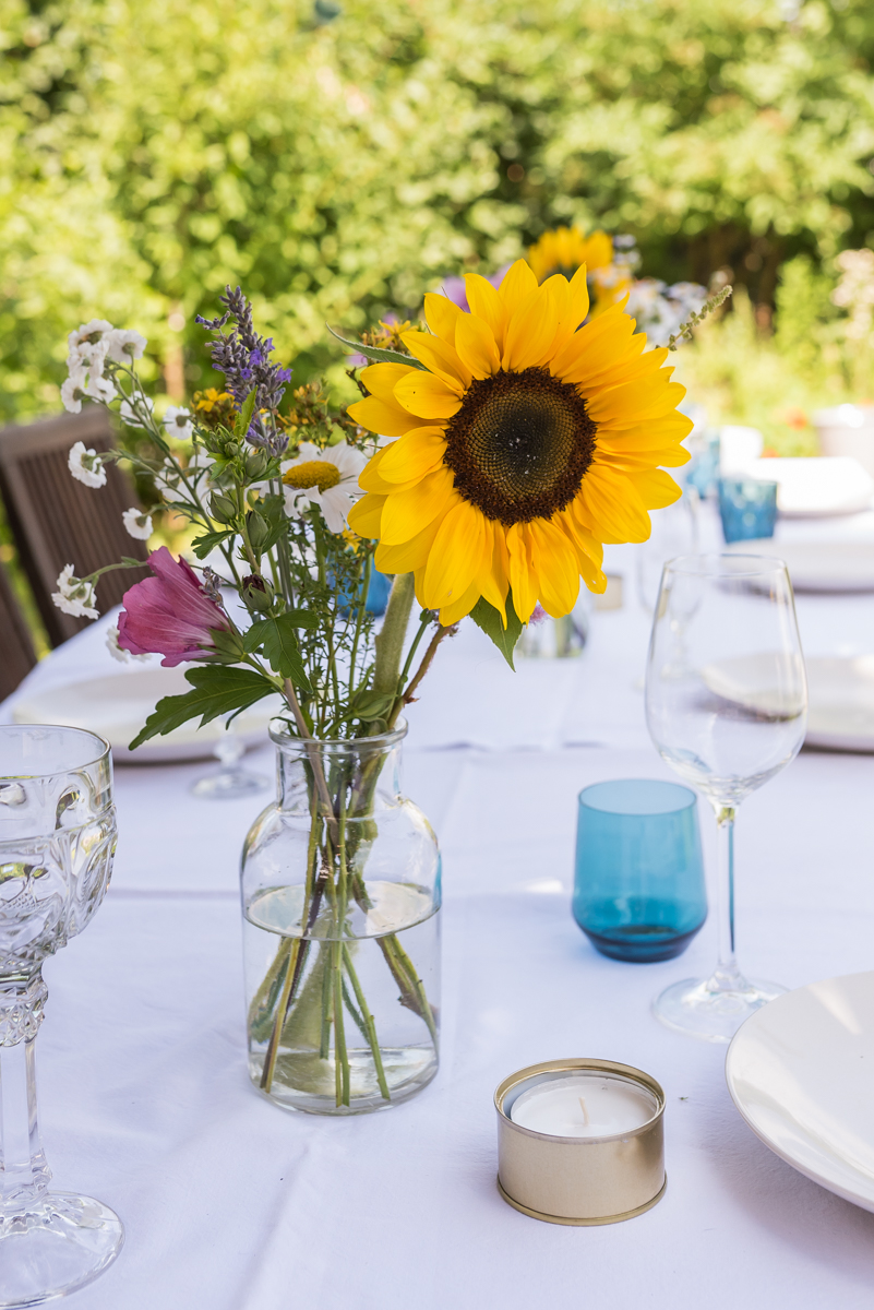 Dekoideen für die Gartenparty im Sommer mit bunten Lampions und Blumen und Leckereien vom Grillbüfett