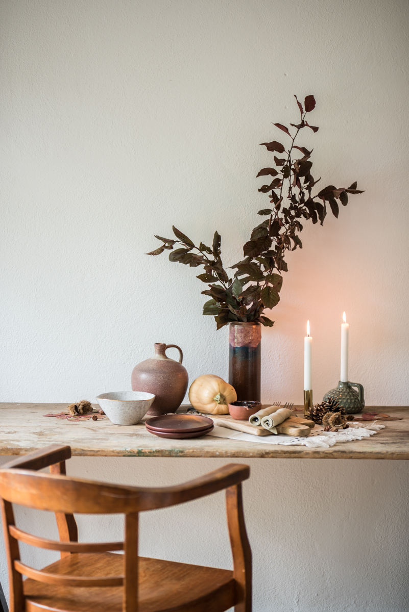 Dekoideen für die Tischdeko im Herbst mit rustikalem Geschirr, Zweigen und Kerzen für das herbstliche Wohnzimmer im modernen vintage Look