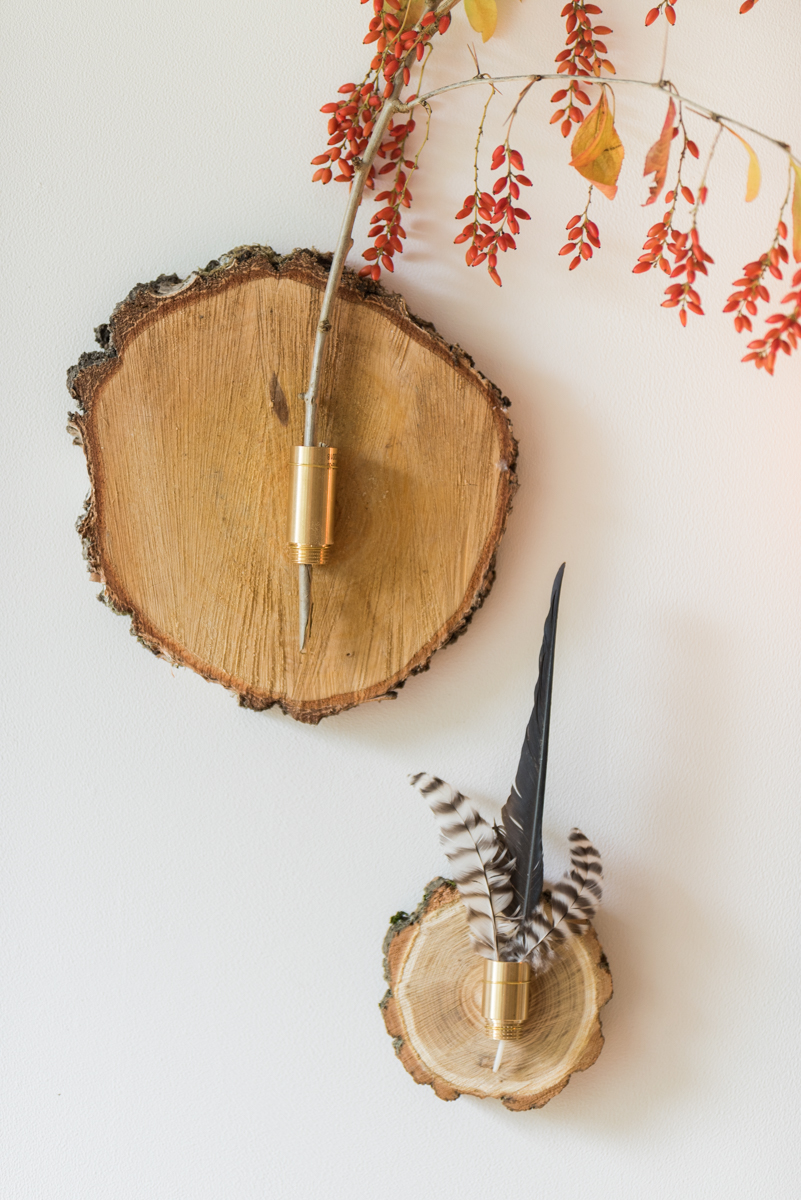 Anleitung für selbst gemachte DIY Deko für die Wand aus Baumscheiben mit Federn und Zweigen als herbstliche Wanddeko für das Wohnzimmer