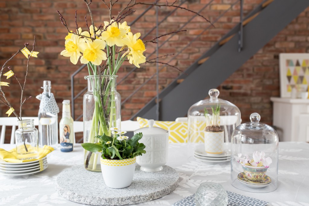 Dekoideen für den Frühling im Wohnzimmer und auf dem Tisch mit Blumen und Deko in sonnigem Gelb 