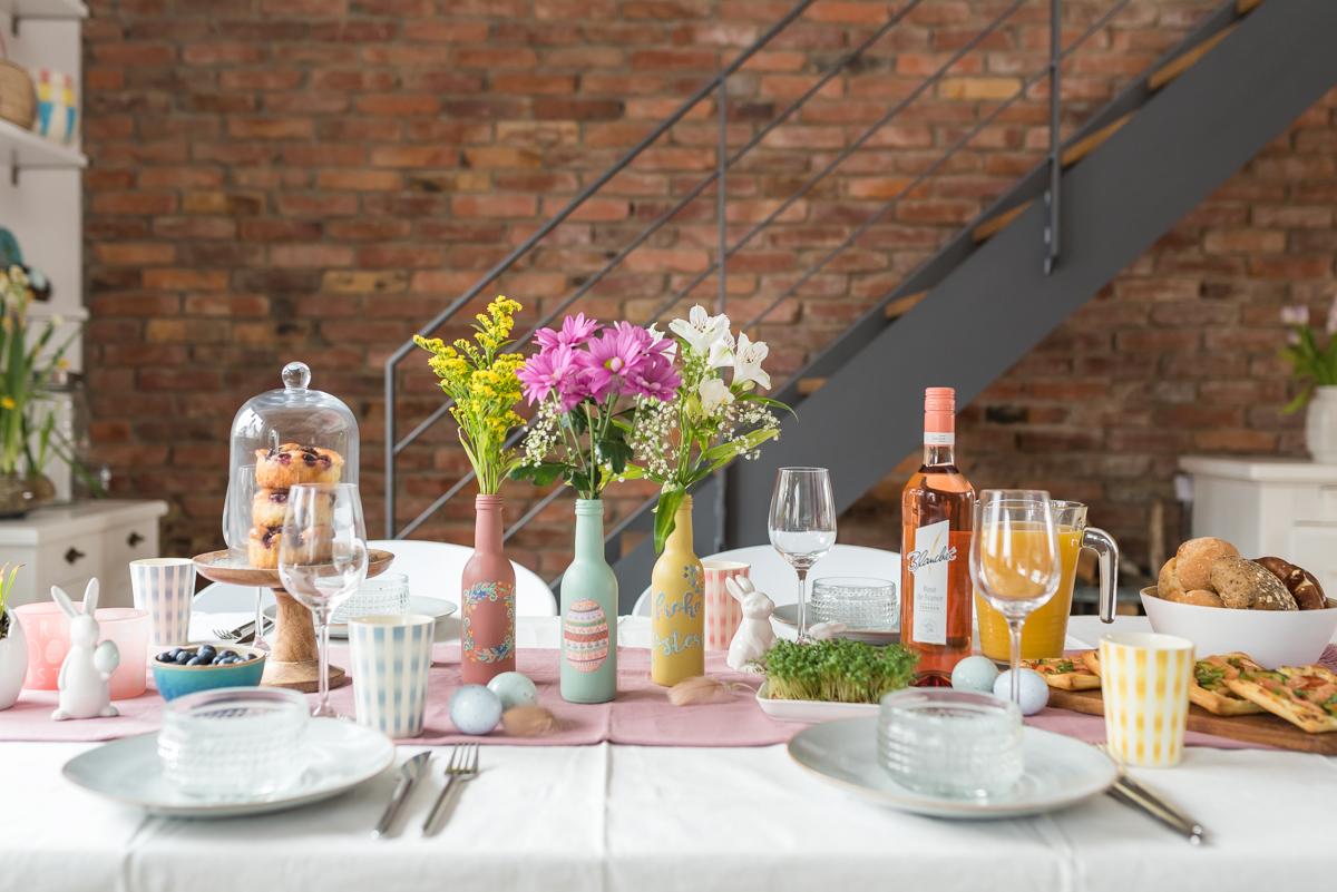 DIY Anleitung für selbstgemachte upcycling Vasen aus Weinflaschen in Pastellfarben als Tischdeko zu Ostern