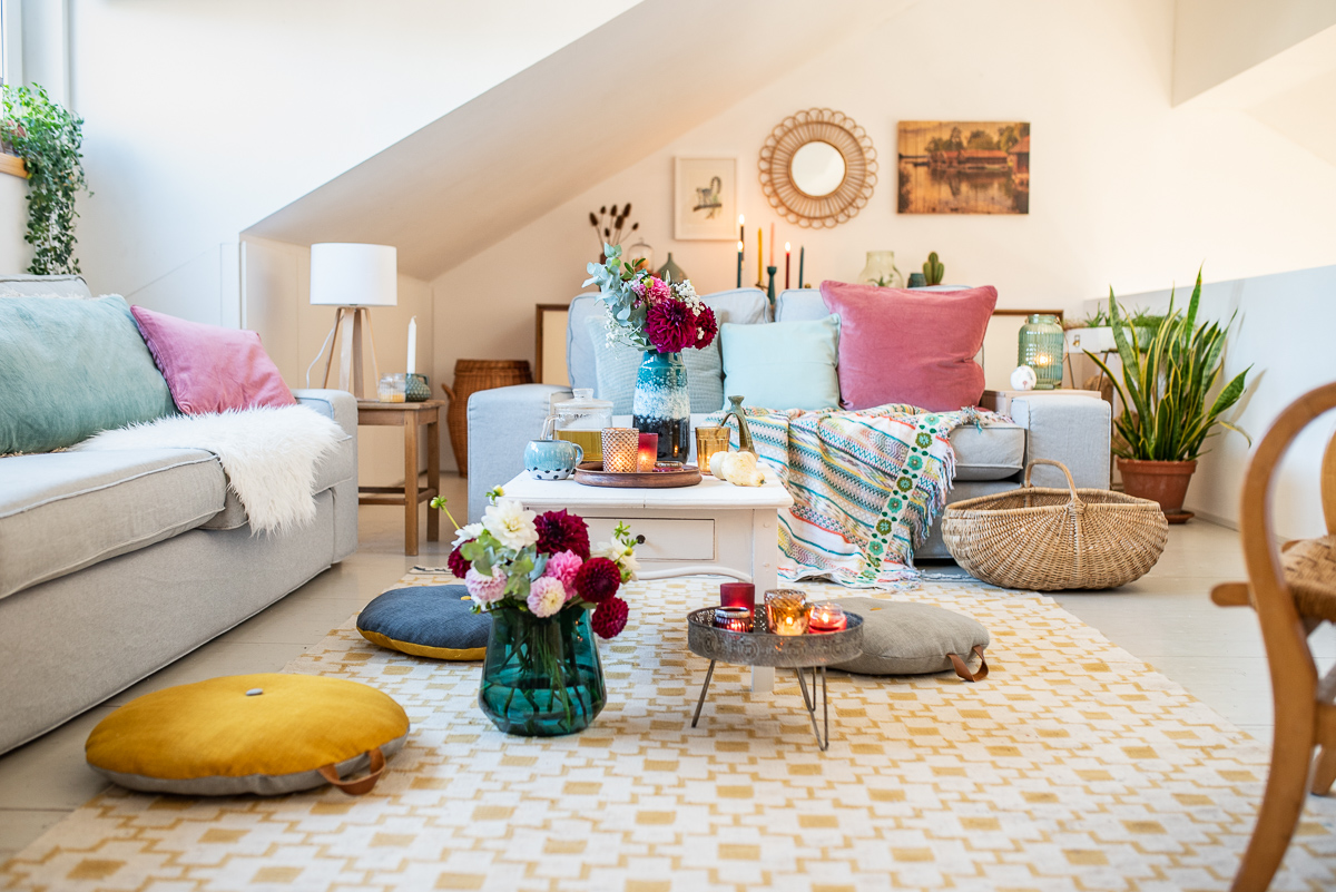 herbstliche Dekoideen für das Wohnzimmer im Herbst mit Kissen in bunten Farben aus Samt, gemütliche Decken für das Sofa, Kerzen und Blumendeko mit Dahlien 