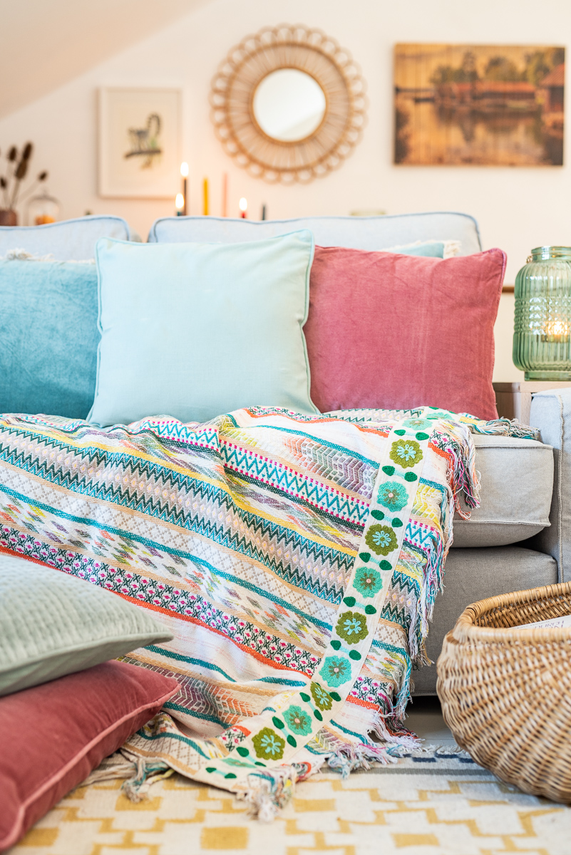 herbstliche Dekoideen für das Wohnzimmer im Herbst mit Kissen in bunten Farben aus Samt, gemütliche Decken für das Sofa, Kerzen und Blumendeko mit Dahlien 