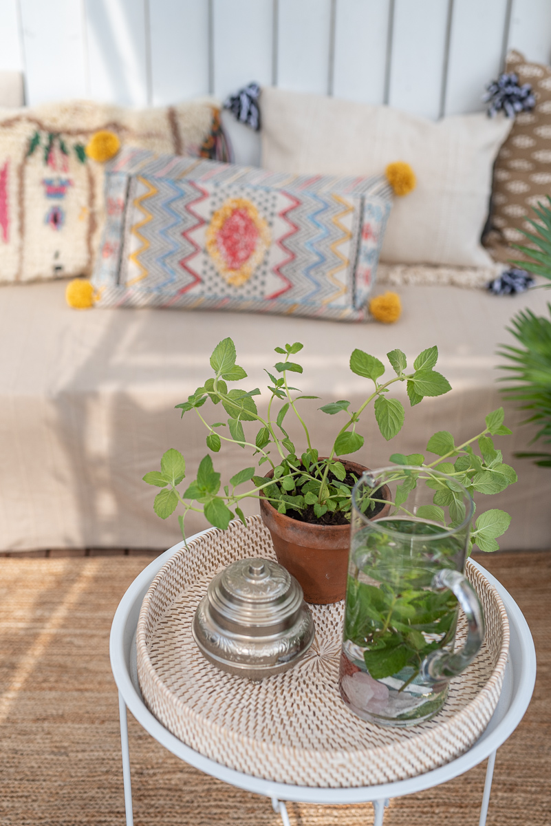 Dekoideen für den Balkon im Sommer im Boho Ethno Look mit Kelim Kissen, Jute Teppich und Pflanzen im orientalischen Stil