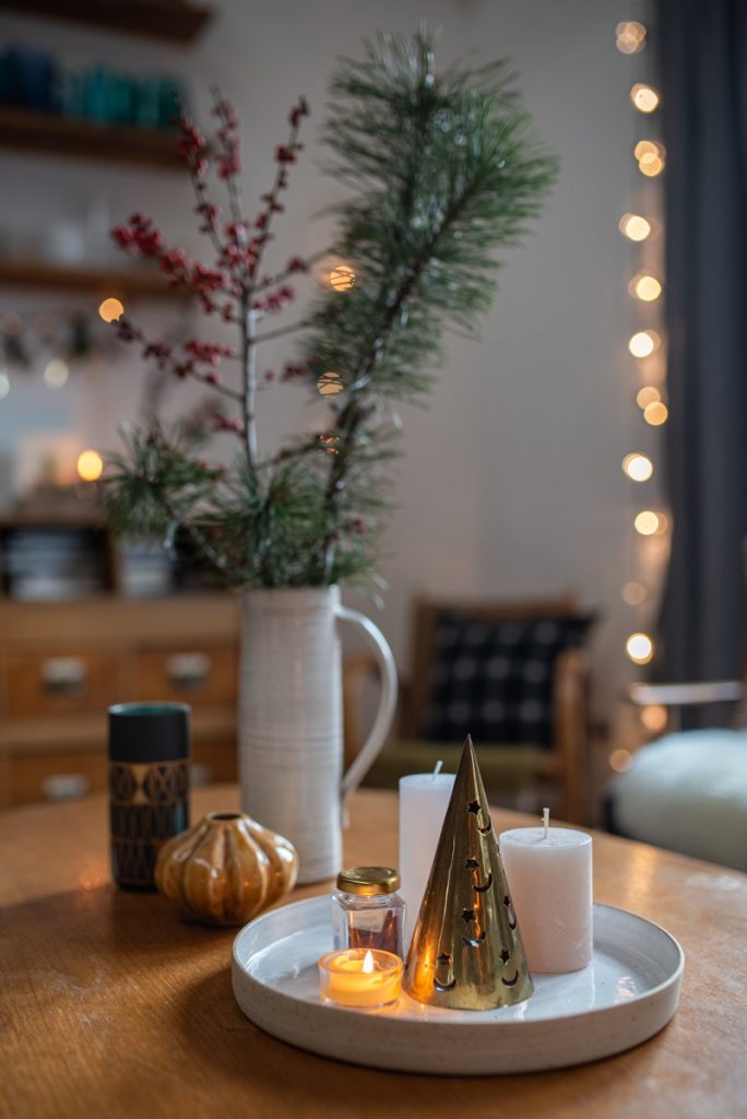 Schnelle DIY Dekoideen für das Wohnzimmer zu Weihnachten im rustikalen Boho Farmhouse Look mit einer Girlande, DIY Sternen aus Kraftkarton und Windlichtern mit Karostoff
